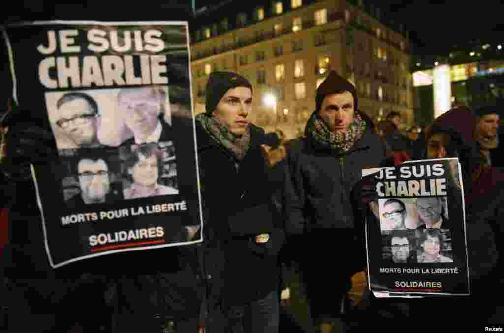 People in front of the Brandenburg Gate in Berlin hold placards that read &quot;I am Charlie,&quot; to pay tribute to the victims of a massacre that killed more than 12 people in Paris, France, Jan. 7, 2015.