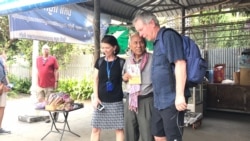 Chum Mey, former victim of S-21 prison, takes a photo with tourists inside the Tuol Sleng Genocide Museum, in Phnom Penh, January 16th, 2020. (Hul Reaksmey/VOA)
