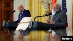 U.S. President Donald Trump and Indian Prime Minister Narendra Modi are pictured in a mirror as they attend a joint press conference at the White House in Washington, Feb. 13, 2025.
