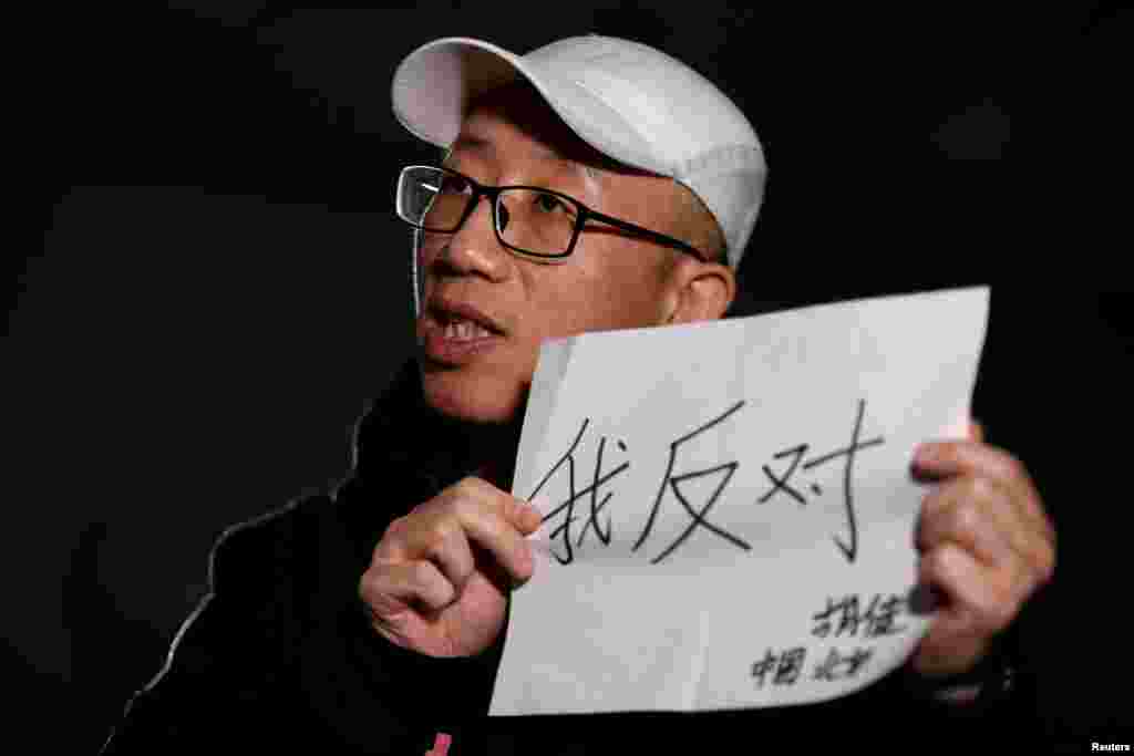 2018年2月28日,在北京接受路透社采访时,中国维权人士胡佳手持标语“我反对”(2018年2月28日)。在两会期间被送出北京度假的异议人士胡佳表示,控制措施非常普遍,尽管当局努力让他和其他人保持沉默,他仍会继续发表意见。他说,明确将一党制合法化的条款和废除两期任期限制都是违宪的。他说:“限制任期是唯一对最高领导者进行权力制衡的机制,他们最多只能有10年的领导权。这个一旦被取消,就不会有任何制衡机制。他可以任职超过10年,甚至一辈子。” 