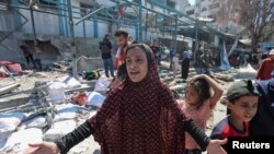 Seorang perempuan Palestina tampak bereaksi ketika berada di gedung sekolah PBB, yang digunakan sebagai tempat penampungan sementara di Nuseirat, Gaza tengah, menyusul serangan Israel ke wilayah tersebut pada 16 Juli 2024. (Foto: Reuters/Ramadan Abed)