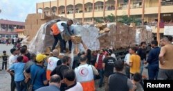 Para pekerja Bulan Sabit Merah Palestina mendistribusikan bantuan pangan kepada Warga di kota Khan Younis, Jalur Gaza (25/10).