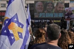 Warga Israel menyaksikan siaran pembebasan Ofer Kalderon, 53 tahun, Yarden Bibas, 34 tahun, dan warga Amerika-Israel Keith Siegel, 65 tahun, yang akan dibebaskan sebagai bagian dari gencatan senjata di Gaza, di Tel Aviv, Israel, Sabtu, 1 Februari 2025. (Foto: AP/Oded Balilty)