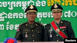 FILE PHOTO: Cambodia's Prime Minister Hun Sen (L) poses with his son Hun Manet on the outskirts of Phnom Penh on October 13, 2009. REUTERS/Chor Sokunthea