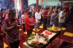 Warga berdoa bersama dalam perayaan Tahun Baru Imlek bernuansa tradisional, "Tumpengan Imlek", di sebuah vihara di Yogyakarta, 23 Januari 2020. (Foto: Antara via Reuters)
