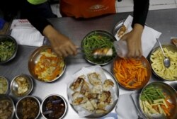 Seorang pekerja MyMeals, sebuah layanan pesan-antar makanan, menyiapkan makan malam untuk penderita diabetes di kawasan Cikokol dekat Jakarta, 25 April 2016. (Foto: REUTERS/Beawiharta)