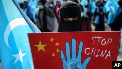 A protester from the Uyghur community living in Turkey holds up an anti-China placard during a protest against the visit of China's Foreign Minister Wang Yi to Turkey, in Istanbul, March 25, 2021.