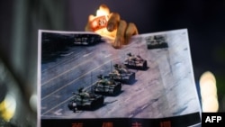 香港抗议如火如荼之时，美国也发生大规模抗议活动。图为在局势动荡的香港，人们仍然为六四举哀：香港维多利亚公园纪念六四事件31周年的一名男子手持天安门广场“坦克人”的照片。（法新社2020年6月4日资料照）