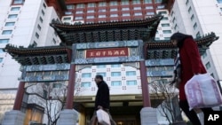 资料照片：居民从北京王府半岛酒店门前经过。(2018年11月16日)