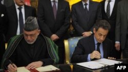 Tổng thống Pháp Nicolas Sarkozy (phải) và Tổng thống Afghanistan Hamid Karzai ký hiệp định hợp tác và hữu nghị tại Điện Élysée ở Paris hôm 27/1/12