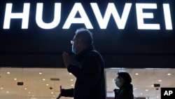 2021年4月12日行人经过北京一家华为电子商店。