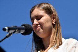 Mantan staf pemerintah Brittany Higgins, berbicara secara terbuka terkait perkosaan yang dilakukan oleh seorang rekan di kantornya, di depan para pengunjuk rasa yang berdemo, menentang kekerasan seksual, 15 Maret 2021. (AFP)