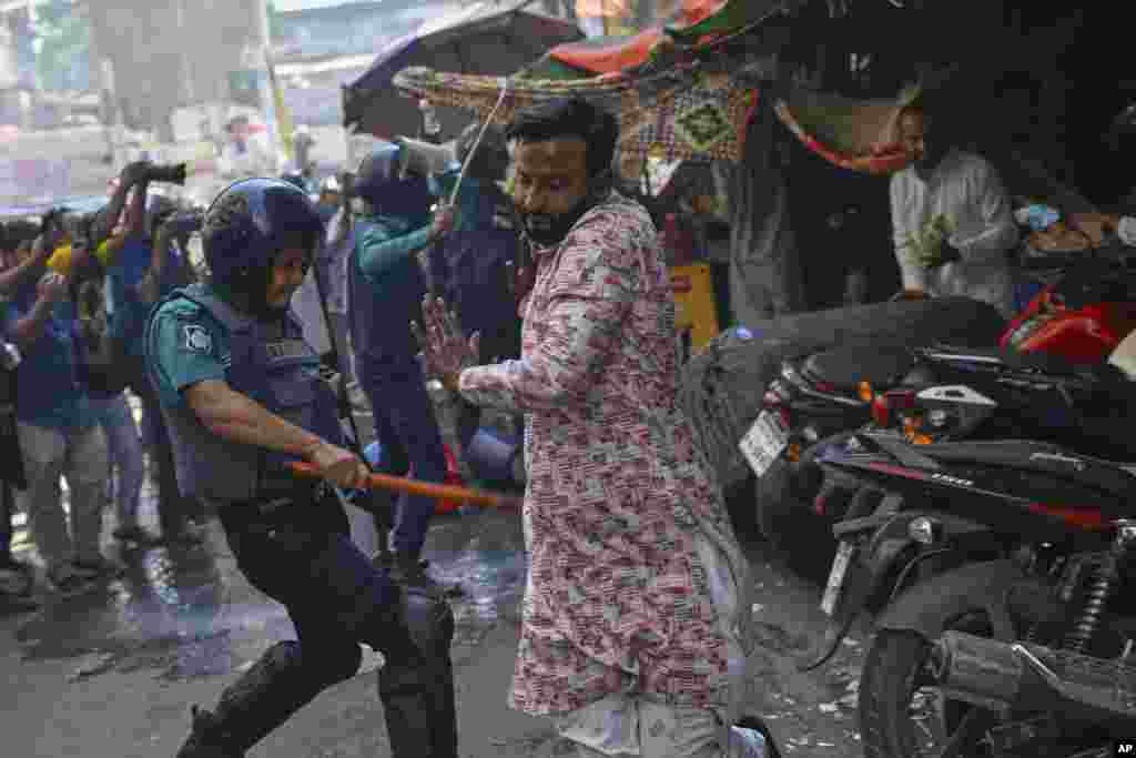 Policemen use batons to disperse supporters of the banned Islamist group Hizbut Tahrir near Baitul Mokarram Mosque in Dhaka, Bangladesh.