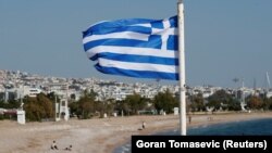 Bendera nasional Yunani berkibar di sebuah pantai, di Athena, Yunani, 28 April 2020. (Foto: Reuters/Goran Tomasevic)