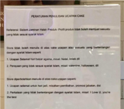 Pengumuman mengenai peraturan penulisan ucapan cake yang terpampang di depan toko
