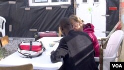 A migrant is seen studying at Zimako Jones' school, one of several makeshift schools at the Jungle camp in Calais, France. (L. Bryant/VOA)