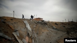 Palestina memeriksa lokasi yang menurut keterangan polisi Gaza merupakan serangan udara Israel di Jalur Gaza utara, 18 Maret 2017. (REUTERS/Mohammed Salem)