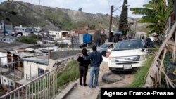 The wife of Mexican photojournalist Margarito Martinez, Maria Elena Frausto Granados (L), accompanied by a relative, looks at the site where he was shot dead near their house in Tijuana, Baja California State, Mexico, on Jan. 17, 2022. 