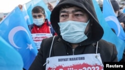 FILE - People from China's Uyghur Muslim ethnic group protest outside the city's Turkish Olympic Committee building, calling for a boycott of the Winter Olympics in Beijing over China's treatment of the minority, in Istanbul, Turkey, Jan. 23, 2022.