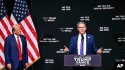 资料照片：2024年8月14日，时为共和党总统候选人的特朗普在北卡罗来纳州阿什维尔聆听投资家贝森特谈论经济问题。