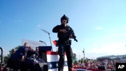 Bakal calon presiden AS dari Partai Republik Donald Trump dikelilingi oleh petugas dari dinas keamanan Secret Service di panggung kampanye tak lama setelah terdengar suara tembakan, di Butler, Pennsylvania, Sabtu, 13 Juli 2024. (Foto: Evan Vucci/AP Photo)