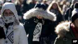 Pedestrians try to keep warm while walking in New York's Times Square, Dec. 27, 2017. Freezing temperatures and below-zero wind chills socked much of the northern United States, and the snow-hardened city of Erie, Pa., dug out from a record snowfall.