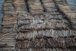 Sebuah tongkang berisi kayu gelondongan ditarik di sepanjang Sungai Mahakam melewati Kota Samarinda, Kalimantan Timur pada 4 November 2021. (Foto: AFP/Aditya Aji)