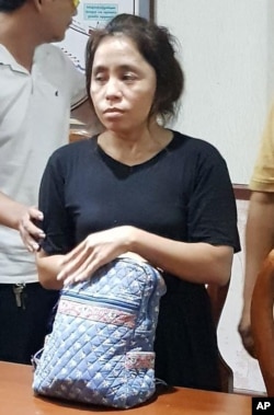 Sam Sokha, who threw a shoe at a billboard depicting Cambodian Prime Minister Hun Sen, stands in police station in Phnom Penh, Cambodia, Feb. 8, 2017. Sam Sokha has been arrested after being repatriated from Thailand where the U.N. refugee agency reportedly had formally recognized her as a refugee.