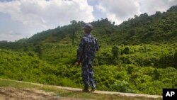 FILE - A Myanmar police officer stands on a road checkpoint in Buthidaung, Rakhine state, on May 28, 2017. The U.N. human rights office warned on May 24, 2024, of “frightening and disturbing reports” of violence against the Rohingya people in Myanmar's Rakhine state. 