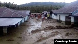 Warga memeriksa kondisi rumah-rumah yang terendam lumpur pasca Banjir Bandang di desa Bangga, Kabupaten Sigi, Sulawesi Tengah. (29/4). (Foto: BPBD Kabupaten Sigi)