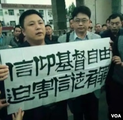 律师程建刚(译音)在中国山东省菏泽市曹县法院外面展示标语 (对华援助新闻网图片)