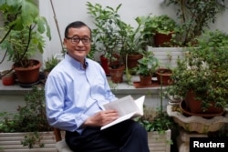 រូបឯកសារ៖ លោក សម រង្ស៊ី អតីត​ប្រធាន​គណបក្ស​សង្គ្រោះ​ជាតិ (CNRP) ដែល​ត្រូវ​បាន​តុលាការ​រំលាយ​ចោល ដែល​កំពុង​រស់នៅ​ភៀសខ្លួន​ក្នុង​ប្រទេស​បារាំង អង្គុយ​នៅ​រានហាល​នៃ​គេហដ្ឋាន​របស់​លោក​ក្នុង​ប្រទេស​បារាំង​នៅ​ថ្ងៃទី ១៩ ខែកក្កដា ឆ្នាំ២០១៨។ (REUTERS/Philippe Wojazer)