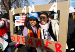 Demonstran Karina Velasco, kiri, dan Gabi Sanchez memegang poster dalam demo mendukung program perlindungan untuk anak imigran atau the Deferred Action for Childhood Arrivals (DACA), dan Status Terlindungi Sementara diCapitol Hill, di Washington, 6 Desember 2017.