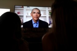 Phoebe Seip (18 tahun), kanan, pelajar SMU Torrey Pines dan saudara perempuannya, Sydney, menyaksikan mantan presiden Barack Obama memberikan pidato secara online untuk kelulusan pelajar SMU, di San Diego, California, 16 Mei 2020. (Foto: Reuters)