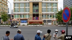 FILE - Security personnel stand across the street in front of Phnom Penh Municipal Court, Aug. 1, 2020.