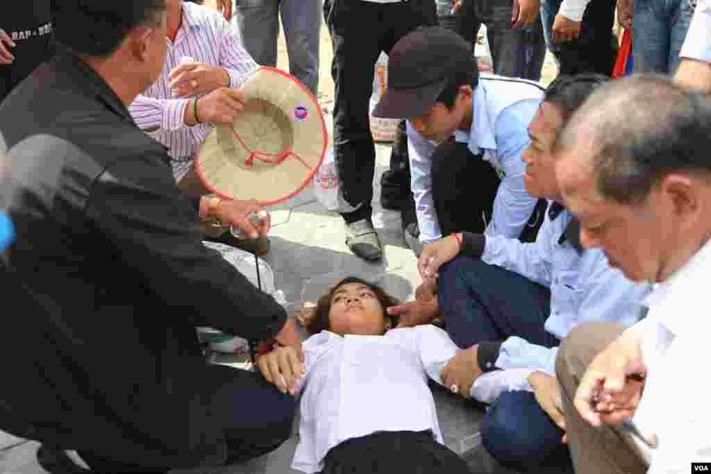A young female protester who passed out due to heat was helped by fellow protesters, Phnom Penh, Oct. 25, 2013. (Heng Reaksmey/VOA Khmer)