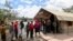 FILE - People stand in line to receive a COVID-19 vaccine, at the Narok County Referral Hospital, in Narok, Kenya, Dec. 1, 2021. 