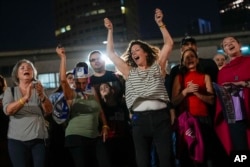 People react as they hear the news of the release of 13 Israeli hostages held by Hamas in Gaza, in Tel Aviv, Israel, on Nov. 24, 2023.