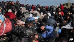 Warga Palestina yang mengungsi berkumpul dengan barang-barang mereka di dekat blokade jalan di Jalan Al Rashid, sambil menunggu untuk kembali ke rumah mereka di bagian utara Jalur Gaza, Minggu, 26 Januari 2025. (Foto: AP)