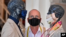 2020年4月23日德国时装设计师站在两个戴口罩的模特当中