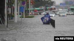 A resident stands on a flooded road in Zhengzhou, Henan province, China July 20, 2021.