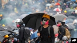 FILE - Protesters face police on a street during a pro-democracy protest, Hong Kong, Aug. 31, 2019. 