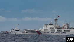 FILE - Kapal Penjaga Pantai China (kanan) melewati kapal Penjaga Pantai Filipina BRP Cape Engaño (kiri), seperti yang difoto dari BRP Cabra selama misi pasokan ke Sabina Shoal di perairan yang disengketakan di Laut Cina Selatan, 26 Agustus 2024. (Jam Sta Rosa / AFP)