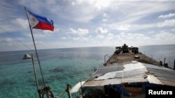 FILE: Bendera Filipina berkibar dari BRP Sierra Madre, kapal Angkatan Laut Filipina yang kandas sejak 1999 dan menjadi detasemen militer Filipina di Second Thomas Shoal yang disengketakan, bagian dari Kepulauan Spratly, di Laut Cina Selatan 29 Maret 2014. (Erik De Castro/REUTERS)