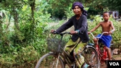 FILE PHOTO - Im Chaem, a former Khmer Rouge cadre, is pictured riding a bike along with her grandson in Along Veng, Oddar Meanchey province, Cambodia, Sunday, April 23, 2017. (Sun Narin/VOA Khmer)