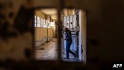 A Syrian man inspects cells at the prison of Saydnaya, north of Damascus, Dec. 16, 2024. The U.S. government suspects Syria ran 40 or more secret prisons, making it difficult to find information on missing U.S. journalist Austin Tice.