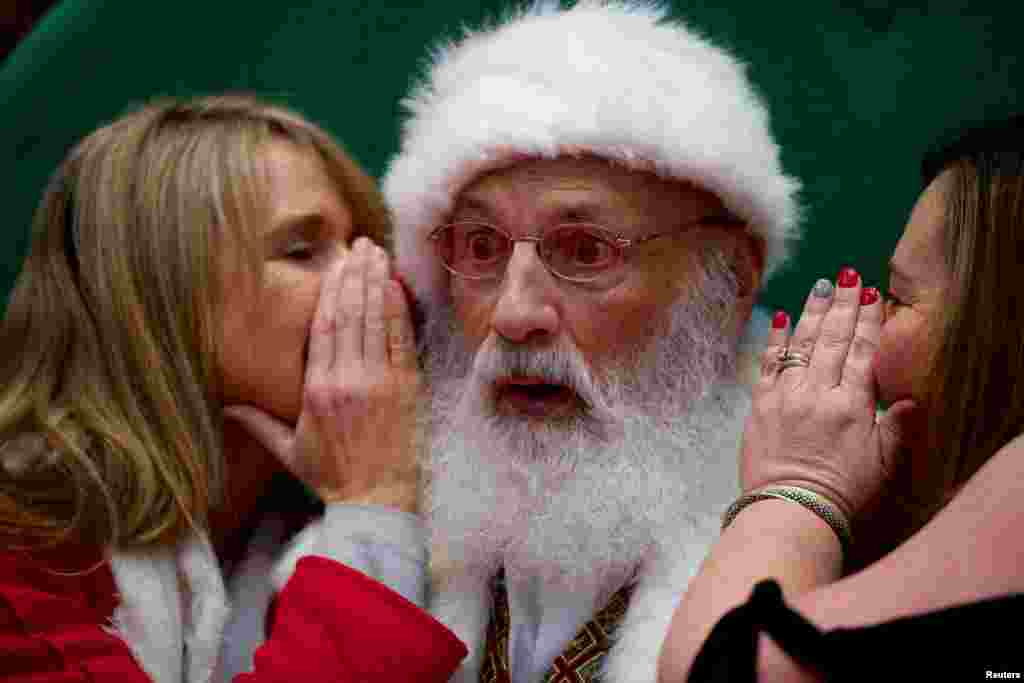 2018年12月8日，在美国宾夕法尼亚州的&ldquo;普鲁士国王&rdquo;购物中心，两位女子向圣诞老人倾诉心愿。这里是美国最大的零售中心。