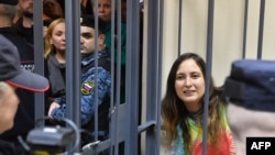 Russian artist Sasha Skochilenko, accused of spreading disinformation about the Russian army for swapping supermarket price tags with messages criticizing the invasion of Ukraine, sits in a defendant's cage during her verdict hearing in St. Petersburg on Nov. 16, 2023.