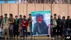 Afghan men stand in front of the supreme court during a protest demanding justice for a woman who was beaten to death by a mob after being falsely accused of burning a Quran last week, in downtown Kabul, Afghanistan, Tuesday, March 24, 2015.