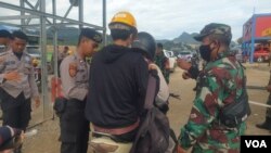 Personel TNI-POLRI melakukan pemeriksaan terhadap pekerja yang hendak memasuki pabrik smelter PT GNI di Morowali Utara, Sulawesi Tengah, 19 Januari 2023 (Foto : VOA/Yoanes Litha)